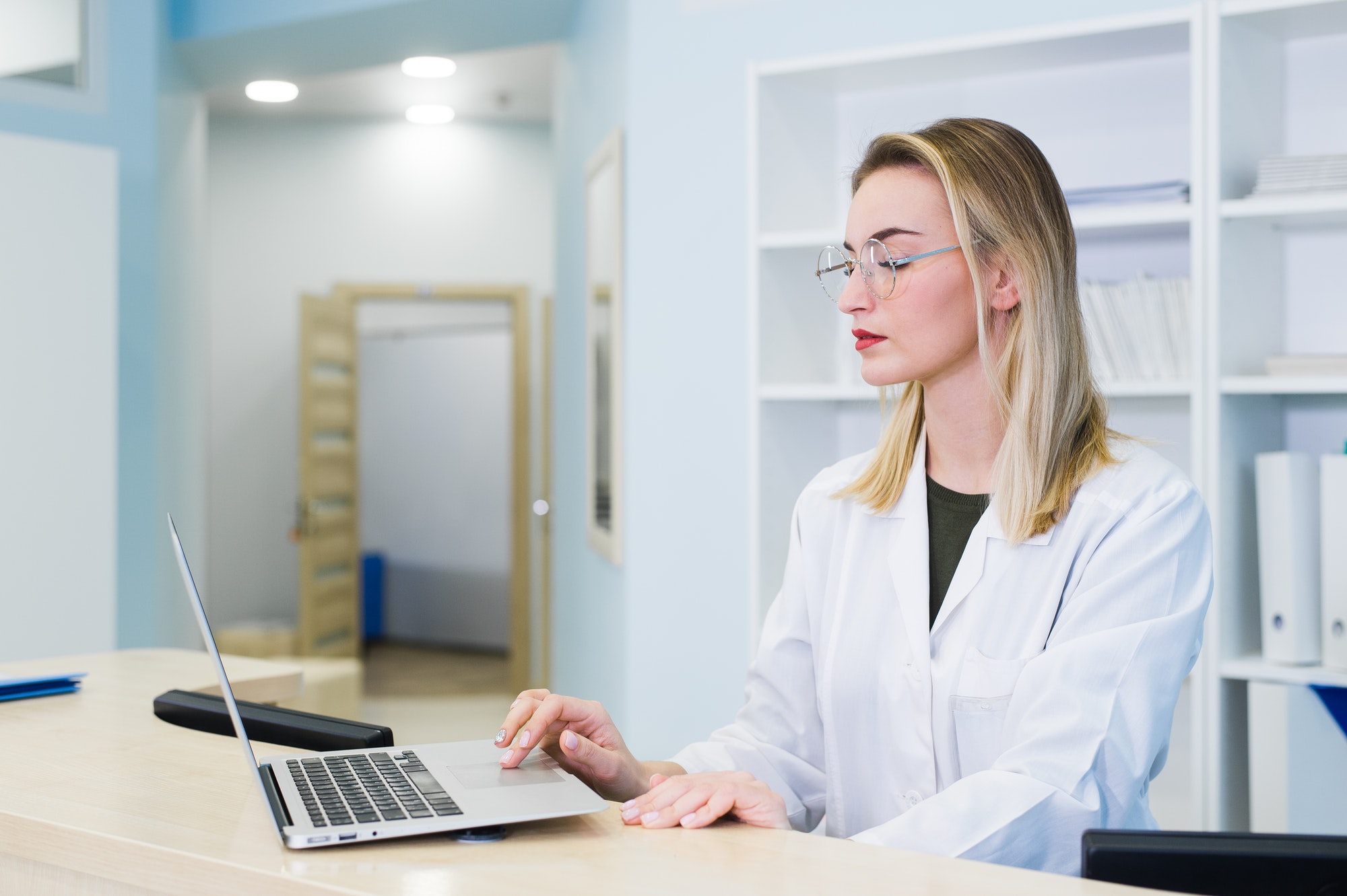 smiling-nurse-with-laptop-scheduling-appointment-for-male-patient-at-reception.jpg